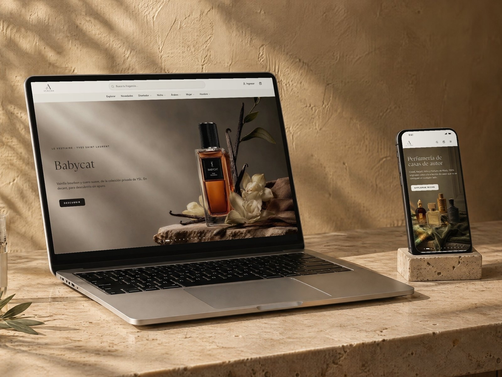 Una laptop y un celular sobre un mostrador de travertino recorren a la vez la portada de aurore.com.pe, animada