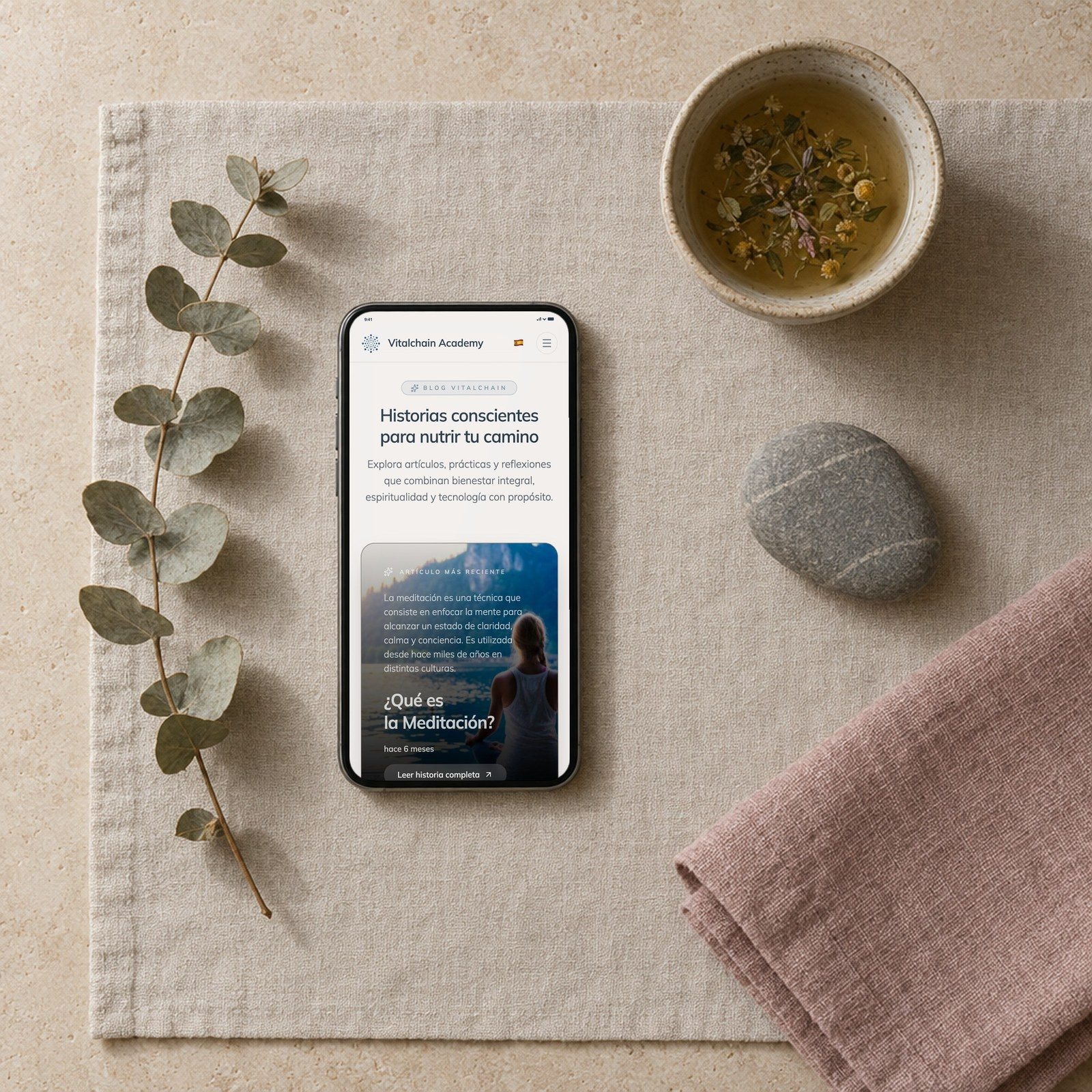 Un móvil con el blog de VitalChain sobre un mantel de lino, con té y eucalipto